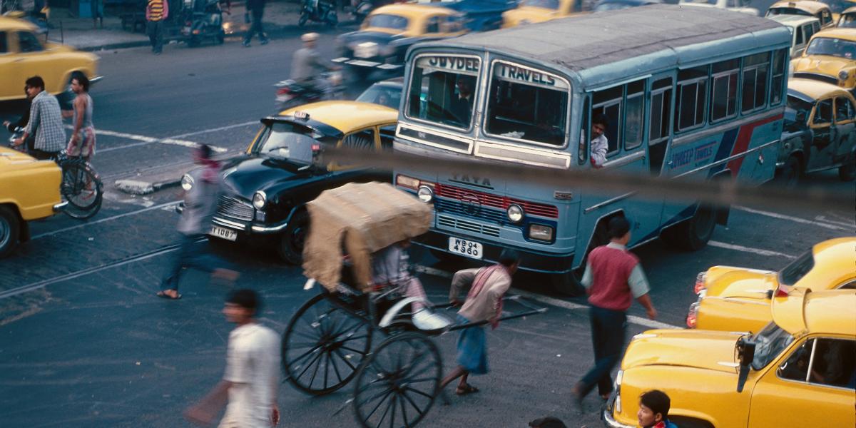 busy traffic scene with taxis, buses, and rickshaws