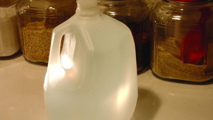 a gallon bottle of water and canisters of rice and other staples
