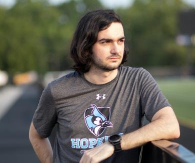 Chris Wilhelm leans on a fence at the Johns Hopkins track