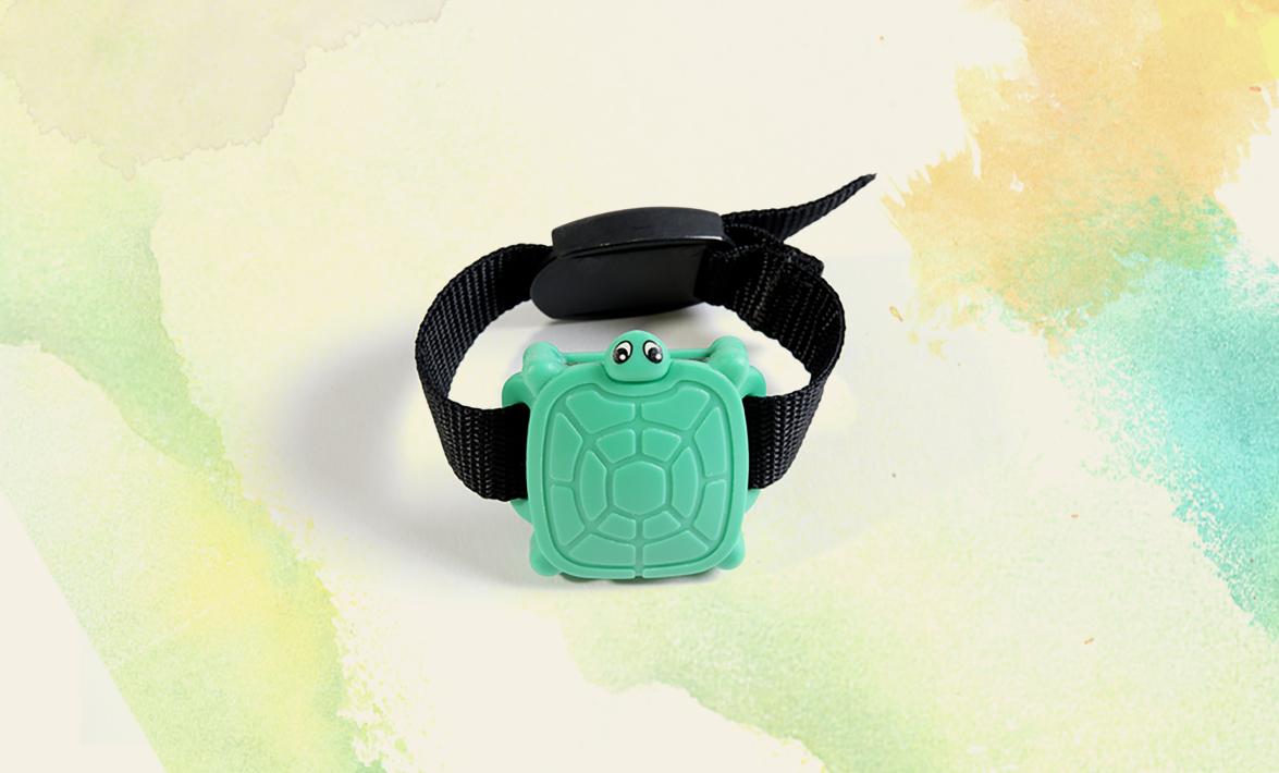 a bracelet with a black strap a green sea turtle