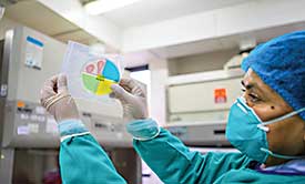 IFHAD team member examines MDR/XDR-TB color diagnostic plate.
